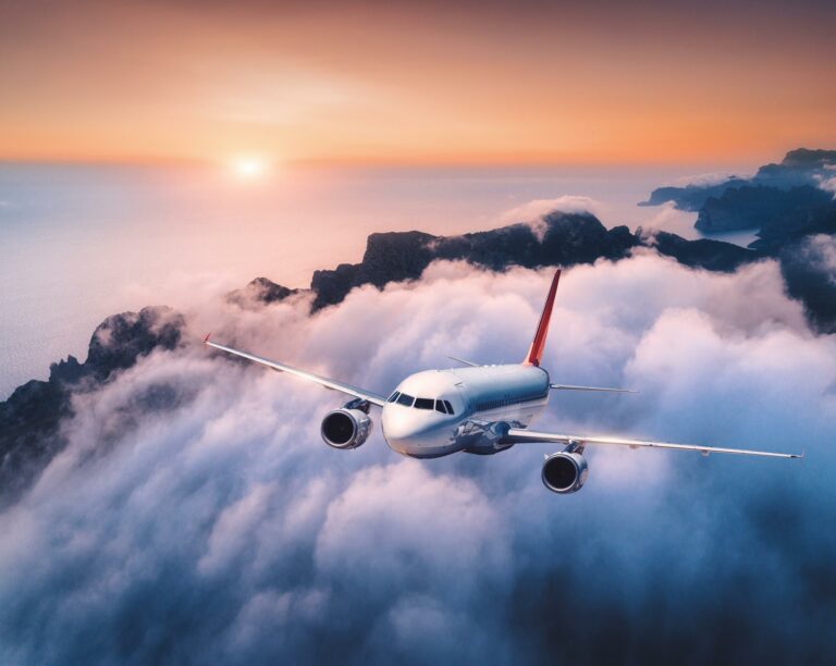 WCL passenger plane flies over clouds at sunset
